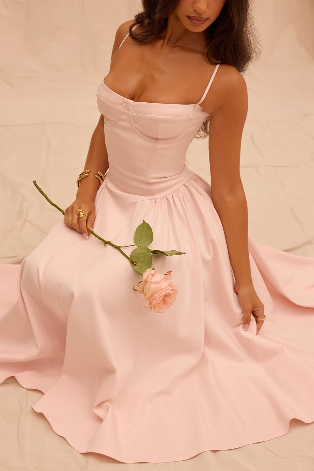 Woman in a pink dress holding a pink rose against a beige background Blush elegant