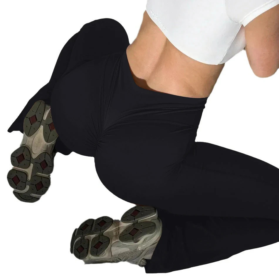 Person wearing Onyx black leggings and gray athletic shoes on a white background